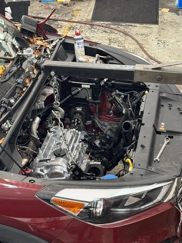 Major engine work at AutoPlus with the engine bay opened up for replacement