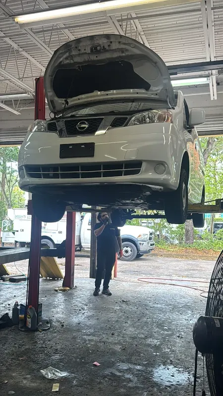 Everyday car raised on a lift inside the AutoPlus repair shop in Lauderhill